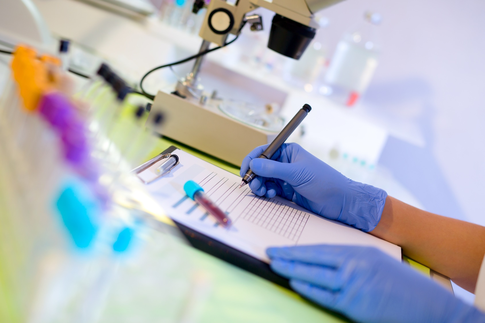 Woman working in a laboratory. He writes with a felt pen. Select focus